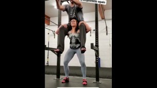 Strong Woman Squats Man on Shoulders